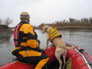 A man and a search dog on a raft on a river